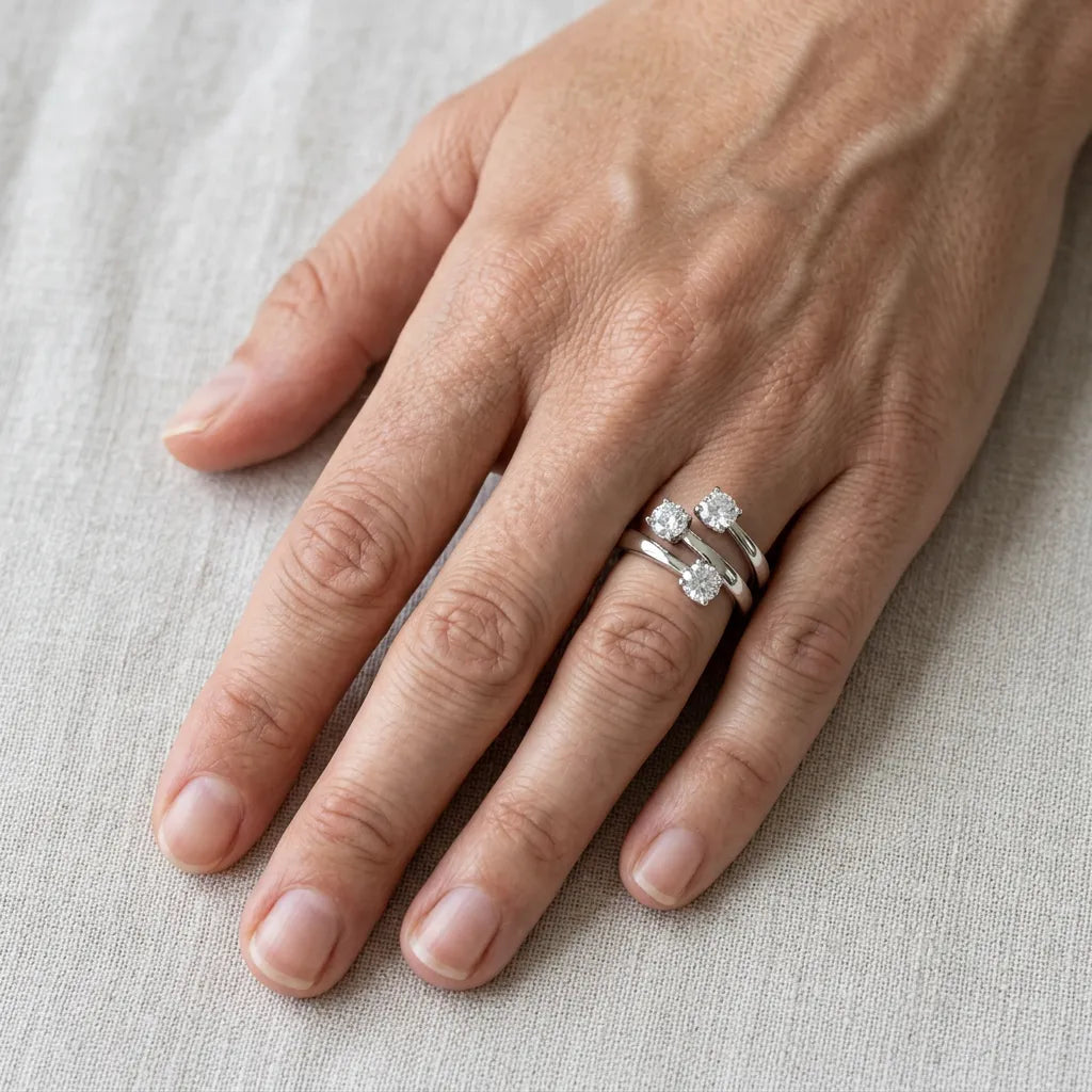 Anello trilogy sfalsato in argento 925 indossato sulla mano appoggiata su tessuto chiaro, per mostrarne le proporzioni.