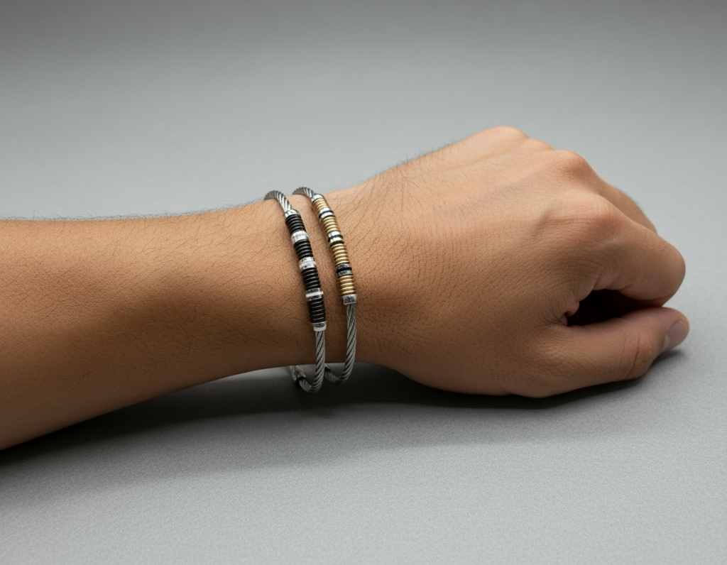 Bracciali rigidi in argento 925 e oro 18k, stile moderno con dettagli intrecciati, indossati al polso.