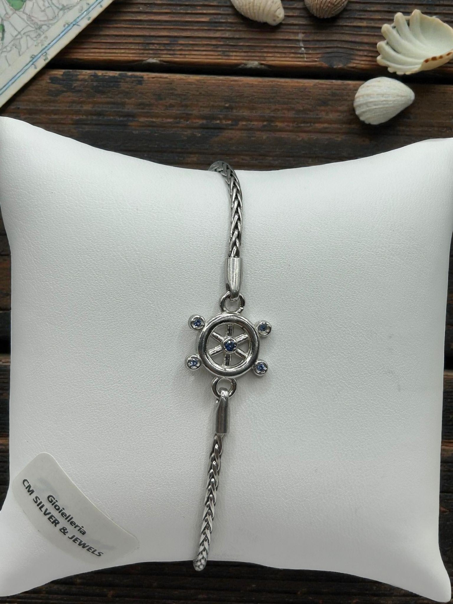 Bracciale in argento 925 con ciondolo timone, stile marinaro e dettagli con pietre blu.