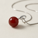 Macro della perla rossa e del sostegno in argento
