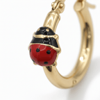 Dettaglio macro coccinella smaltata rossa e nera su orecchino cerchio oro 18k, lavorazione artigianale – CM Silver Jewels