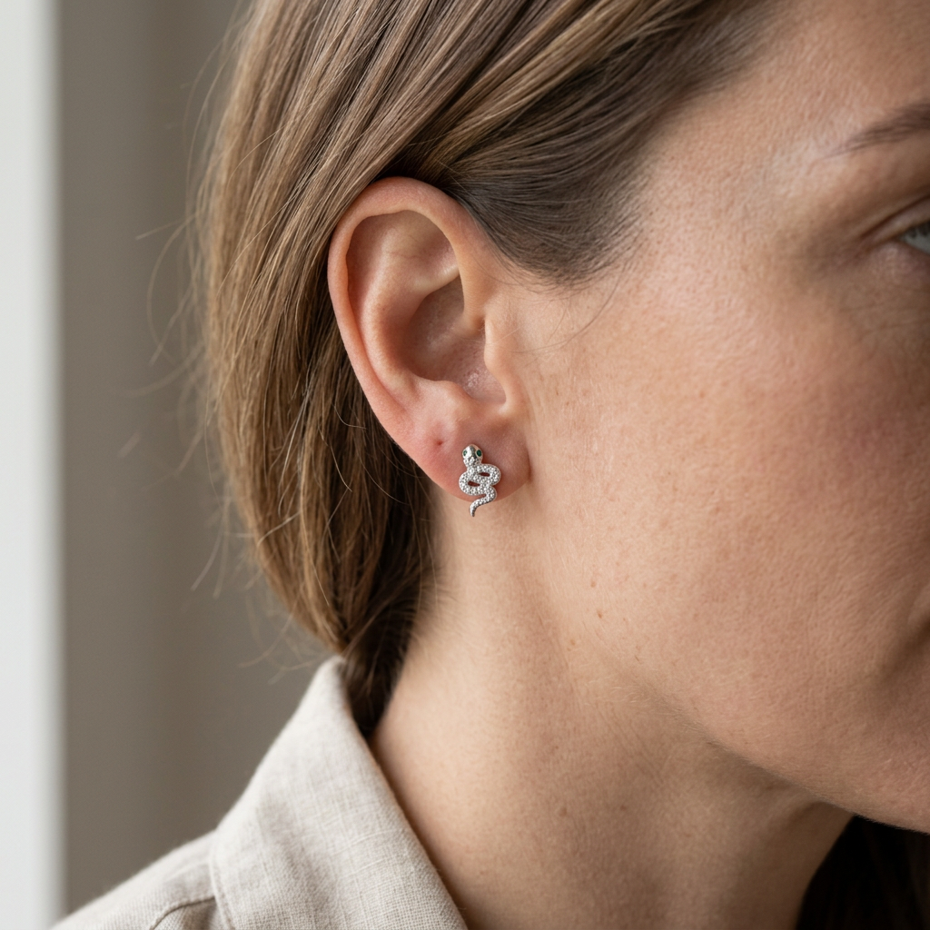 Vista di profilo dell’orecchino serpente con occhi verdi indossato